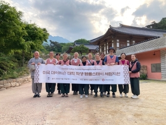 a group of students and adults standing together in front of a Buddhist temple