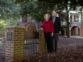 an older couple standing next to a gate