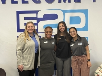 a group of young women standing in front of a wall that reads "E2D"