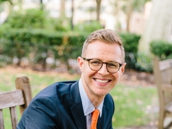 a young white man wearing glasses and suit and tie