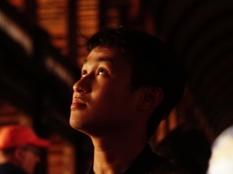 a young man in a dark setting looking up