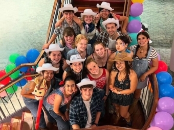 a group of students wearing cowboy hats surrounded by balloons and smiling