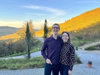 a young couple standing in front of a mountainside