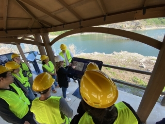 Sustainability Scholars with hardhats visiting a reservoir