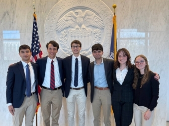 a group of six young people standing in front of the federal reserve building