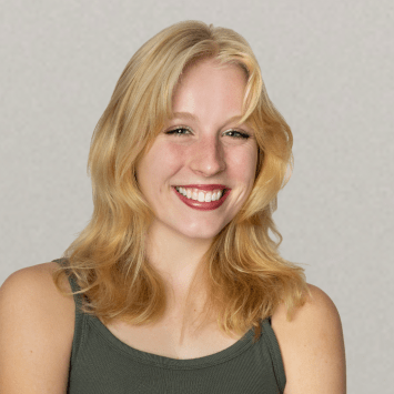 a young white woman with blonde hair wearing a green tank top