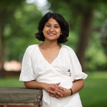 a young woman wearing white standing on a campus