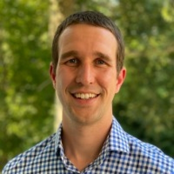 a young white man wearing a blue collared shirt