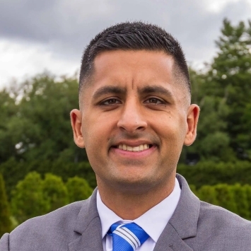 a young man with black hair wearing a suit and tie