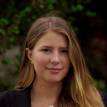 a young white woman with caramel hair wearing a blazer