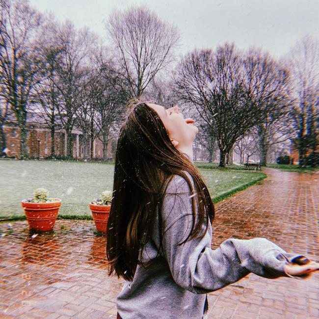 student catches snowflakes on her tongue