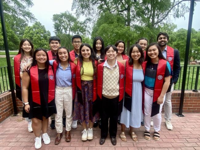a group of students wearing red sashes and smiling