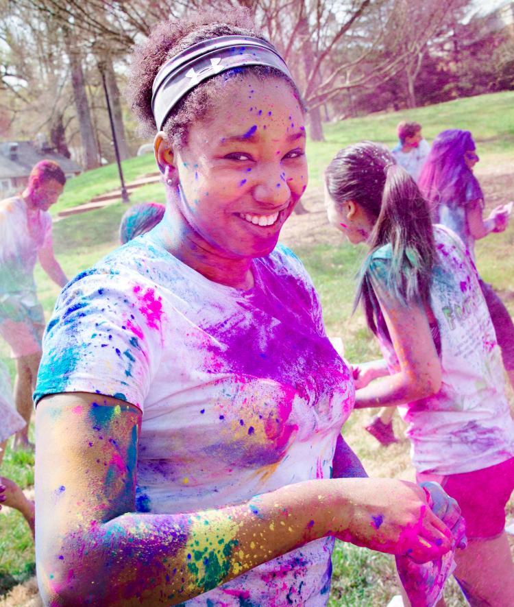 Student is covered in colorful powders during Holi celebrations