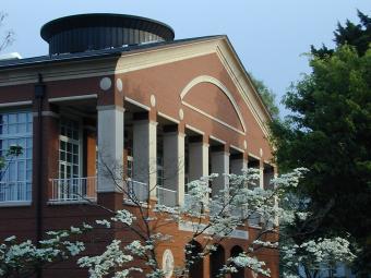 Belk Visual Arts Center exterior, framed by a dogwood tree and pink flowers