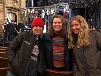 a group of three white women smiling in a theater